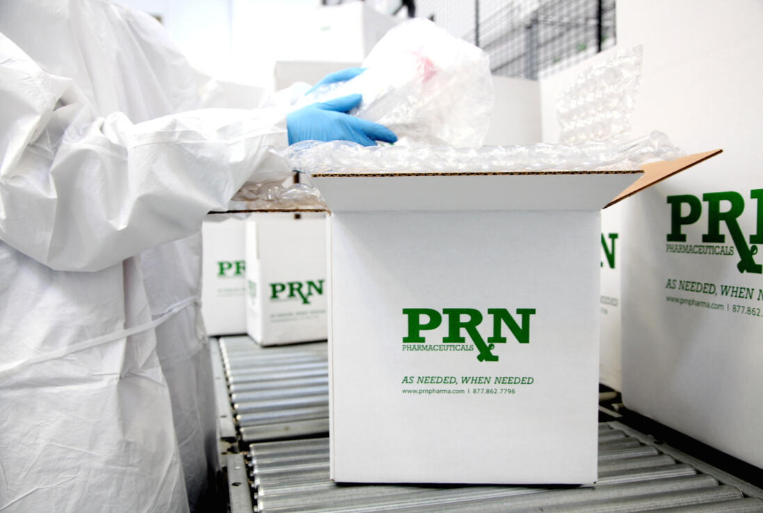 Premium Rx National team packing outbound pharmaceutical shipments on a fulfillment line.