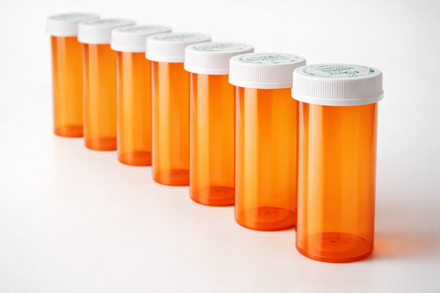 Orange prescription vials with white child-resistant caps in a row.